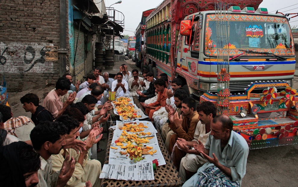 Пакистанские водители молятся перед разговением на третий день священного месяца Рамадан в Лахоре