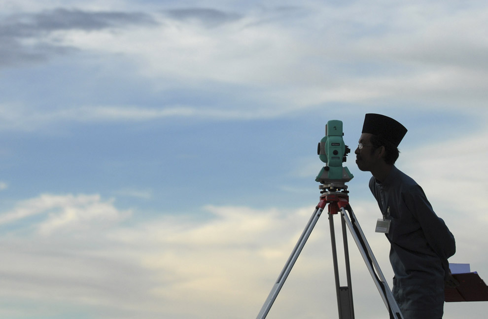 Представитель Исламской власти Бруней смотрит в телескоп, пытаясь определить новолуние