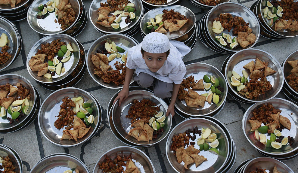 Мальчик готовит пищу к Ифтару (бесплатной раздаче еды) в мечети «Мемон»
