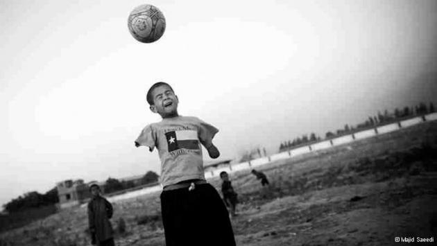 Безрукий афганский мальчик играет в футбол