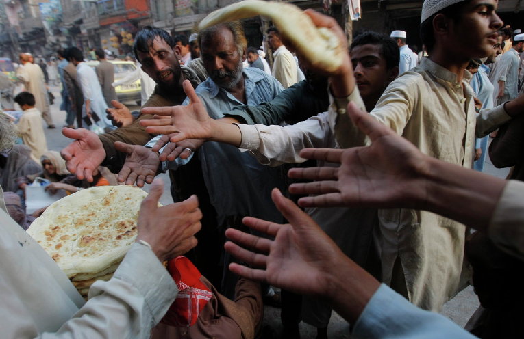 Раздача хлеба беднякам во время священного месяца Рамадан в Пешаваре