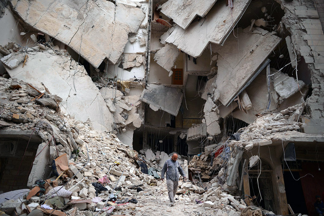 Сириец на руинах города Алеппо