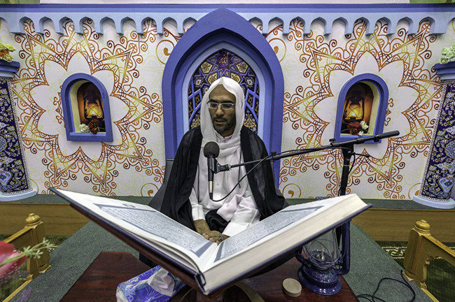 Саудовский религиозный деятель зачитывает копию Корана