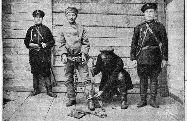 Заключенного облачают в кандалы